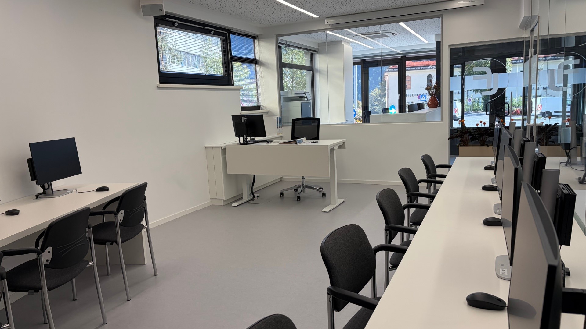 computerraum mit schreibtischen, computern und stühlen für die prüfung